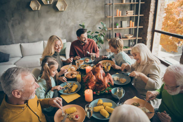 au-dessus du portrait de vue d'angle élevé de la grande pleine famille gaie soeur de frère de frère mangeant appréciant la nourriture domestique de repas de saison des plats reconnaissants dans la maison intérieure industrielle moderne de modèle ind - thanksgiving dinner party feast day turkey photos et images de collection