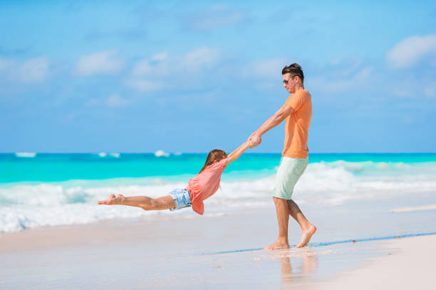 istock Little girl and happy dad having fun during beach vacation 1179009379