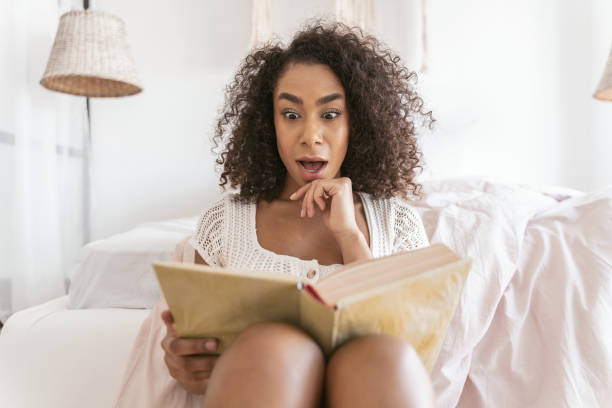 istock Emotional brunette woman staring into her book 1179010781