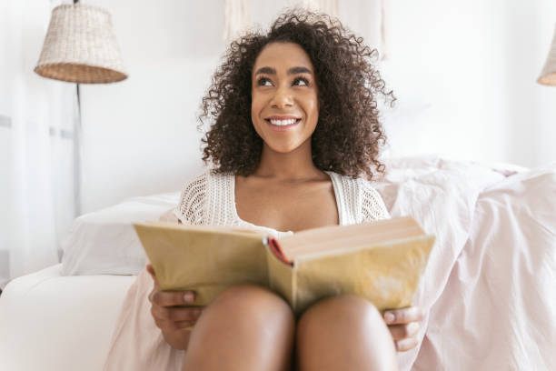 istock Cheerful young female person reading thick book 1179010840