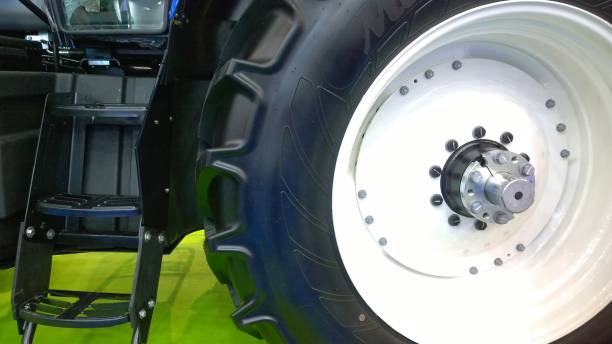 Tractor wheel: stamped white steel disc and tire with tread. The design of the mounting assembly using flanges and hex head screw. Ladder to the driver's cab. Automotive industry development concept. rueda del tractor: disco de acero blanco estampado y neumático con banda de rodadura. el diseño del conjunto de montaje mediante bridas y tornillo de cabeza hexagonal. escalera a la cabina del conductor. concepto de desarrollo de la industria automotriz.