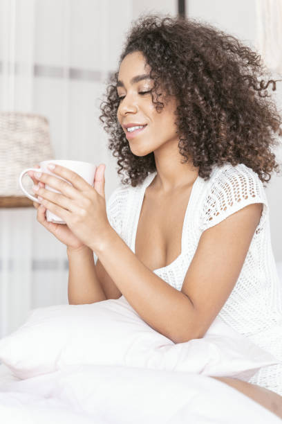 istock Cheerful curly haired woman looking at cup 1179011038