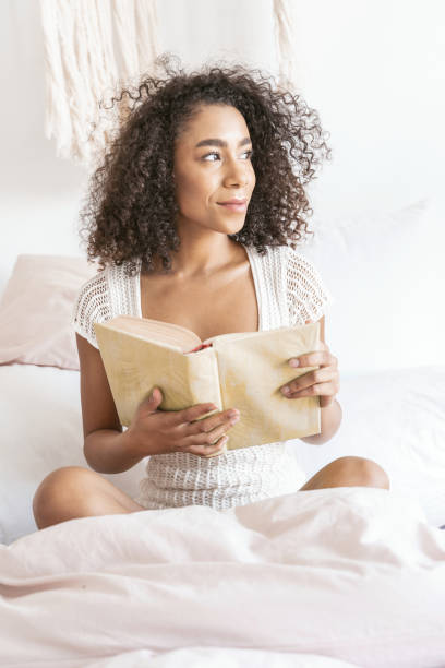 istock Charming international girl holding book in both hands 1179011062