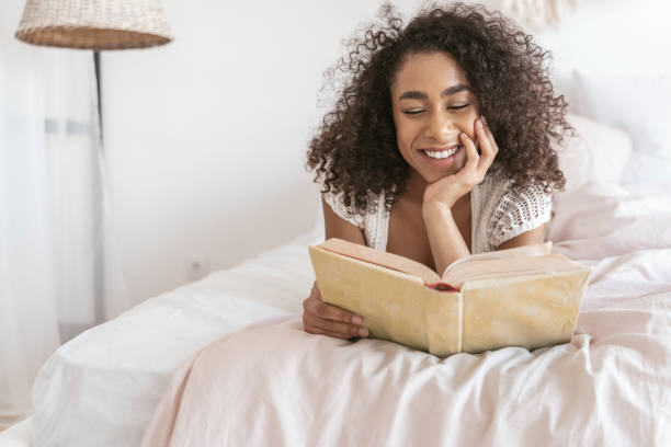 istock Beautiful curly haired girl reading favorite book 1179011080