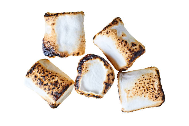 Scattered pieces of fried on barbeque sweet tasty marshmallows cylindrical form isolated on white background. Top view Scattered pieces of fried on barbeque sweet tasty marshmallows cylindrical form isolated on white background. Top view marshmallow photos stock pictures, royalty-free photos & images