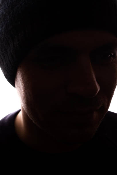 istock Portrait young man, unshaven, side view in cap - dark silhouette 1179013558