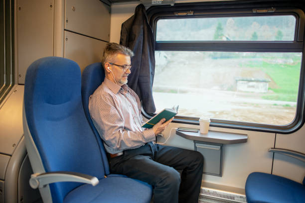 istock Businessman reading book and traveling by train 1179013596