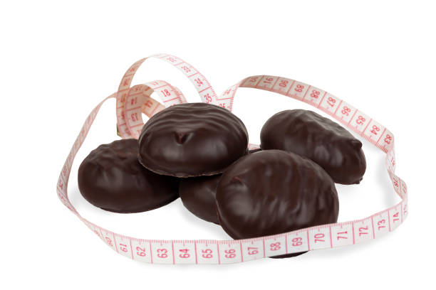 istock Chocolate marshmallows with measuring tape on a white background. Close-up. 1179014369