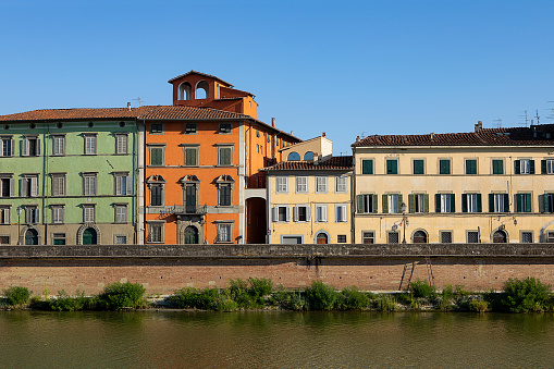 Cityscape of Pisa. Multi colored facades of houses of Pisa. Historic tenements by the Arno river. Pisa, Tuscany, Italy. Old town city street.
