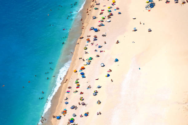 istock Bright sandy beach with many people and turquoise water from above 1179016504