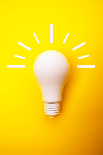 istock Spray painted white light bulb on yellow background with White Rays Illuminating out 1179019403