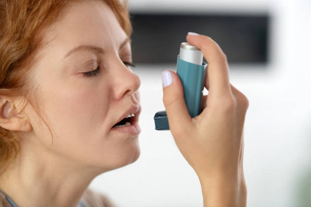 istock Young woman closing her eyes while applying inhalator 1179020501