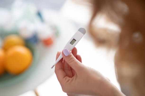 istock Close up of woman holding thermometer while checking temperature 1179020774