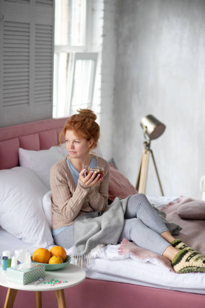 istock Woman spending day in cozy bedroom while having flu 1179020781