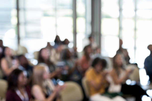 A defocused photo of a diverse audience at the weekend conference.