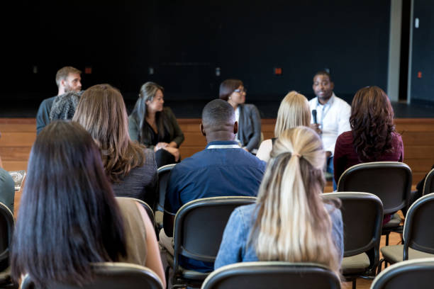 baksida bild av publiken lyssnar på panel presentation - stadshus bildbanksfoton och bilder