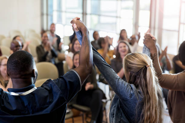 istock Unrecognizable panel links hands and raises arms in victory 1179025364