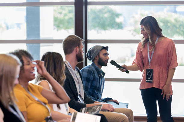 istock Mid adult assistant holds microphone for hipster's question 1179025394