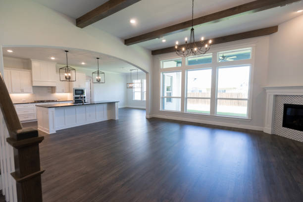 Empty home Empty living area and kitchen inside of a new modern home. The sun shines through lare windows in the living area. model home photos stock pictures, royalty-free photos & images