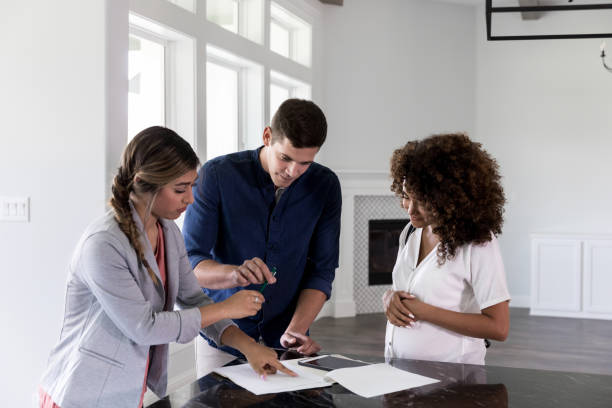 istock Couple sign documents in new home 1179026130