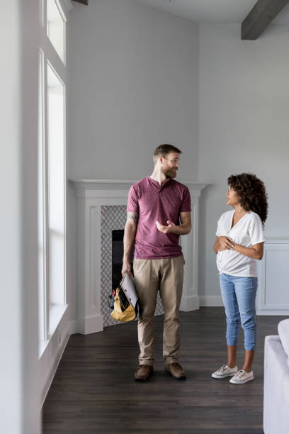 istock Home repairman talks withe woman in new home 1179026151