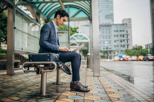 istock Man using laptop at bus station 1179026154
