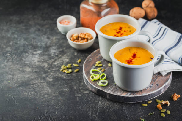 sopa de calabaza en una taza de metal en tablero de madera - pumpkin soup soup cup pumpkin fotografías e imágenes de stock