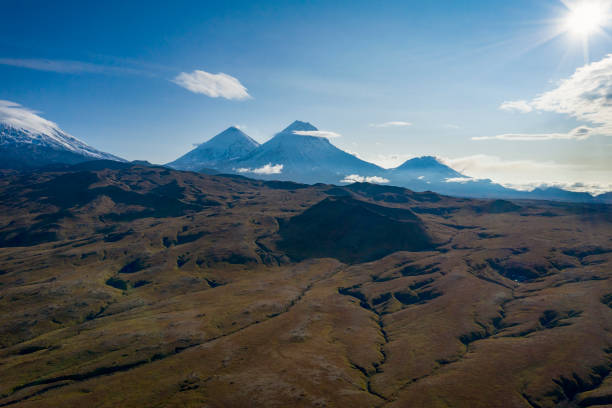Aerial view of Mt. Klyuchevskoi (or Klyuchevskaya Sopka, 4750 m, in the back left) and Mt. Kamen (4.579 m, in the center of the image). Mt. Klyuchevskoi is the highest mountain on the Kamchatka Peninsula of Russia and the highest active volcano of Eurasia. The volcanos are part of the natural Volcanoes of Kamchatka UNESCO World Heritage Site.