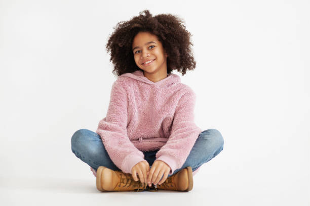 Cute laughing girl in casual clothes Cute laughing girl in casual clothes sitting against white background girl sitting stock pictures, royalty-free photos & images