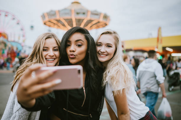 groupe d'amis de femmes adolescentes appréciant la foire d'état - mobile phone group of people photographing teenager photos et images de collection