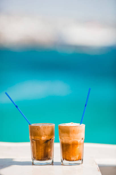 istock Coffee latte on wooden table with sea background 1179044046