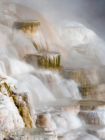 Close up of travertine (imestone) terraces at Canary Spring, Mammoth Hot Springs, Yellowstone National Park, Wyoming, USA. Terraces composed of travertine (limestone) deposited from hydrothermal waters. Colors produced by thermophiles, algae and minerals.