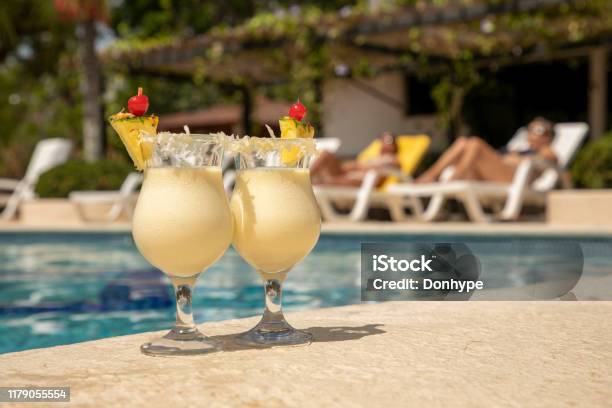 Two Glasses Of Pineapple Colada At The Edge Of A Pool Stock Photo - Download Image Now