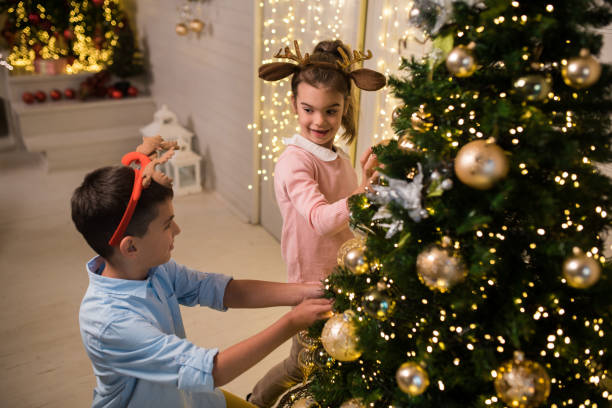 istock Boy and girl decorating the Christmas tree 1179058501