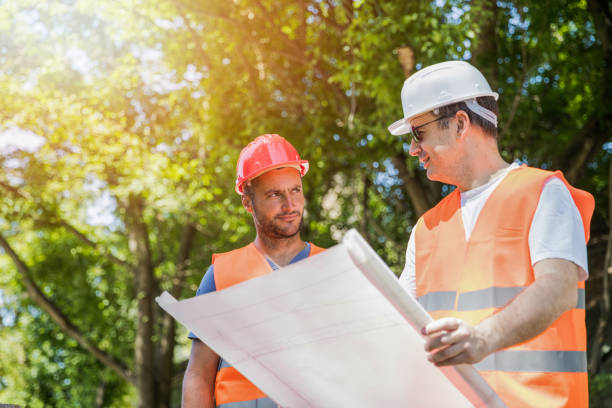 istock Supervisor showing blueprints to worker on building site 1179061984
