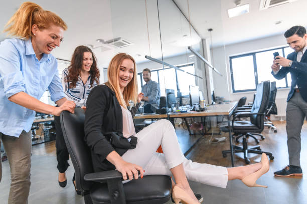 istock Carefree Business Colleagues Racing Chairs Through Office 1179065021