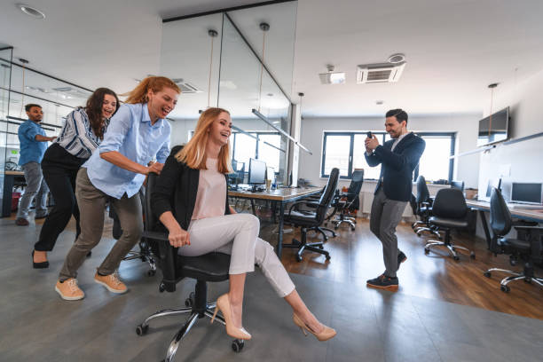 istock Carefree Business Colleagues Racing Chairs Through Office 1179065029