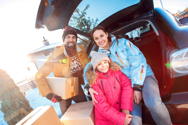 Moving to new apartment. Family together outdoors standing sitting at car with boxes smiling cheerful close-up stock photo