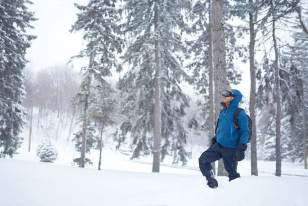 istock Smiling diverse couple holding Christmas presents while walking through a winter forest 1179065942