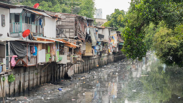 Slums and polluted canal in Bangkok. Stock image with logos removed Slums along a smelly polluted canal (Khlong Toei) full of mud and garbage in Khlong Toei District. Stock image with logos removed. association of southeast asian nations photos stock pictures, royalty-free photos & images