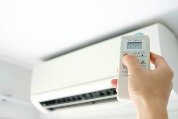 istock Man's hand using remote control open The air conditioner is cooled to 25 degrees Celsius in his bedroom. Health concepts and energy savings 1179086740