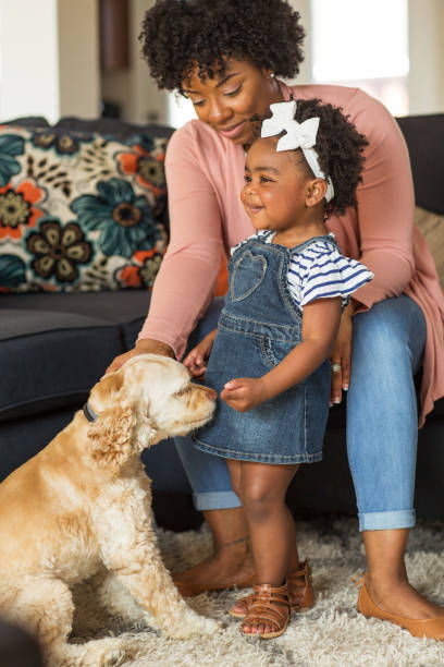 istock Little girl and her mom playing with thier dog. 1179086828