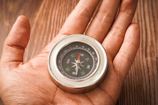 istock Metallic compass on wooden background 1179097095