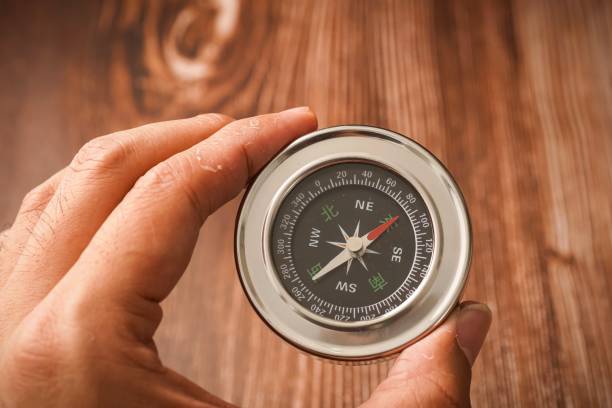 istock Metallic compass on wooden background 1179097096