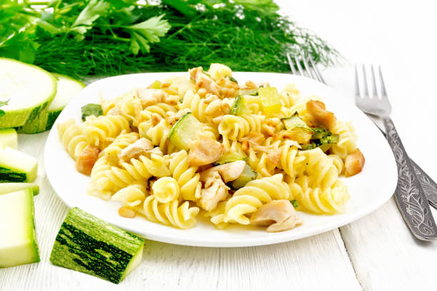 istock Fusilli with chicken and zucchini in plate on light wooden board 1179100535