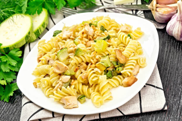 istock Fusilli with chicken and zucchini in plate on wooden board 1179100549