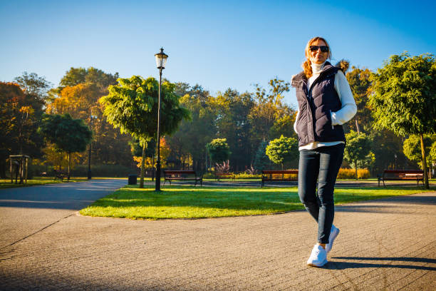 istock Middle-aged woman walking in city park 1179103076