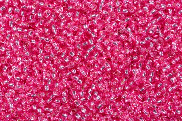 Close up of shiny pink seed beads. High resolution photo.
