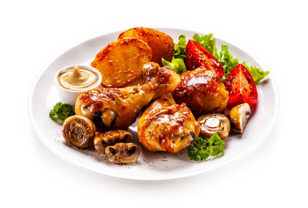 istock Roast chicken drumsticks with fried potatoes and vegetables 1179105051