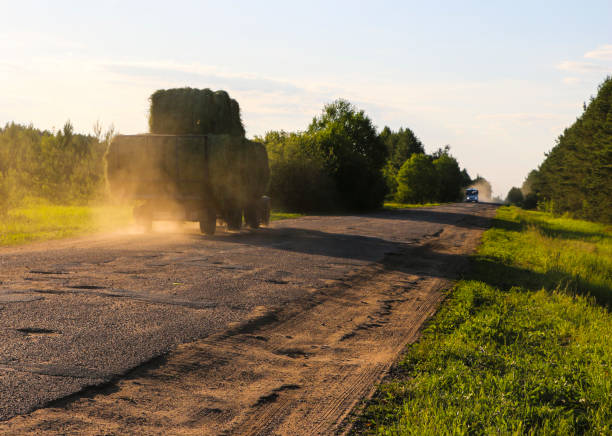 istock tractor driven fresh hay rolled, after seasonal harvesting 1179107251
